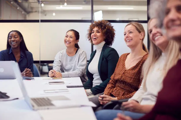 Business Setup Consultants in Dubai - Group of people sitting at a table during a meeting with laptops and documents. 