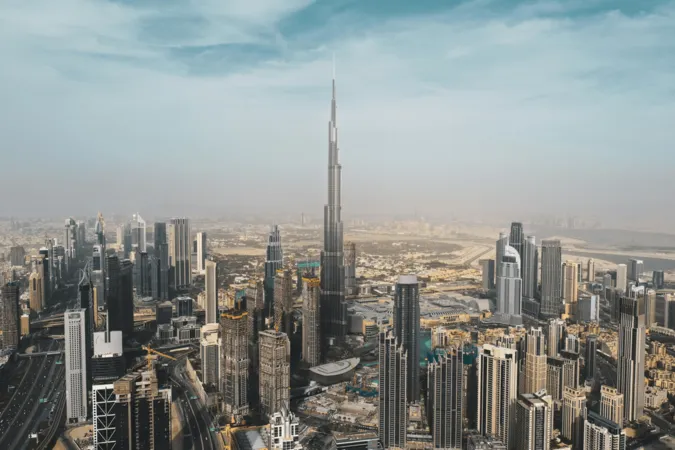 business set up companies in dubai  - Aerial view of a sprawling cityscape with towering skyscrapers under a hazy sky.